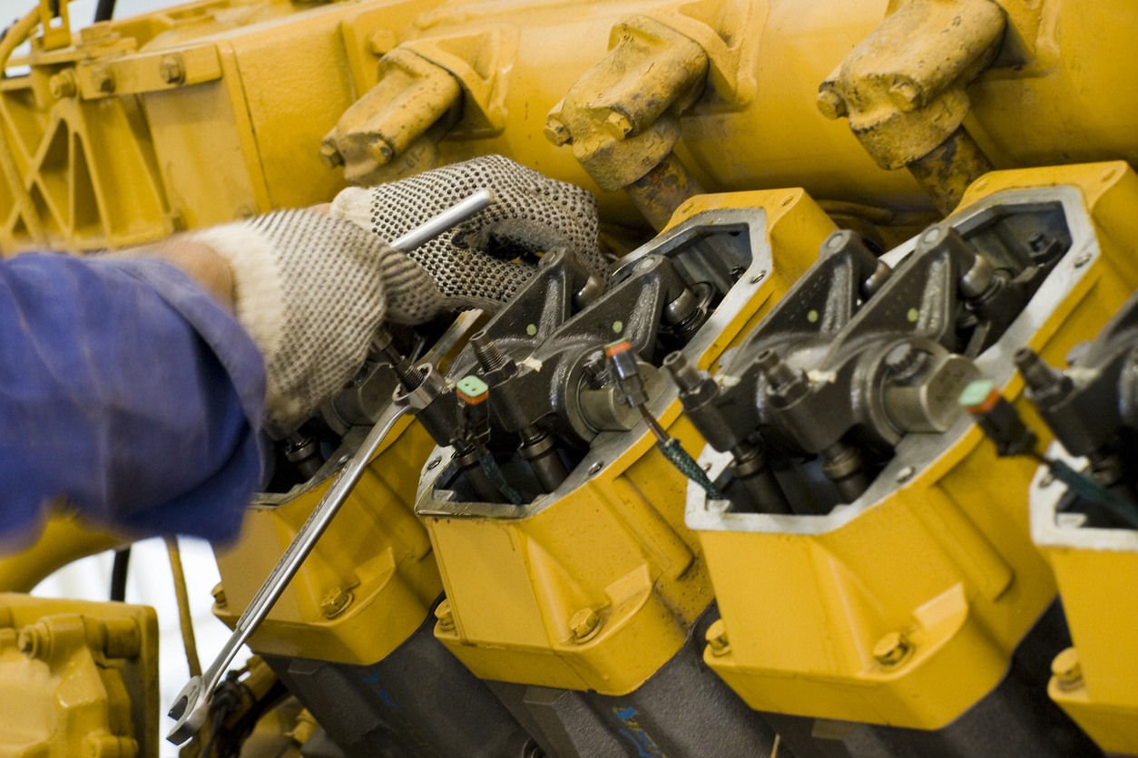 A technician performing periodic engine maintenance in a landfill gas recovery plant