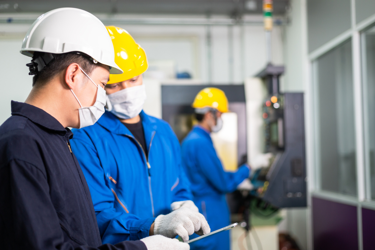 A heavy machine technician reviews key performance data with a business owner/operator