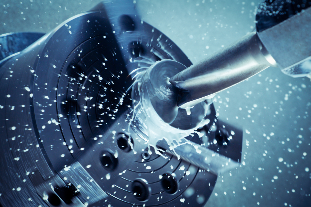A high-speed drill bit spins, slinging water off in a radial pattern.
